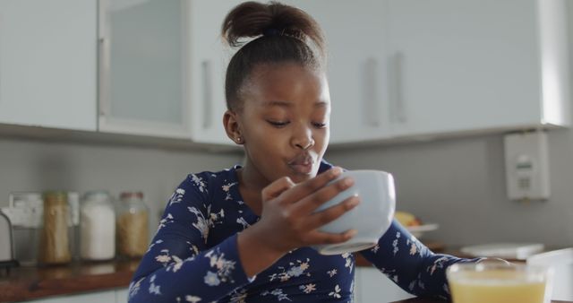 Young Girl Enjoying Breakfast in Modern Kitchen - Download Free Stock Images Pikwizard.com