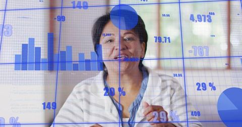 Senior Indian woman presenting analytics, gesturing in home office with charts and graphs overlay