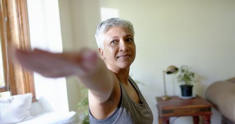 Senior Woman Practicing Yoga in Sunlit Room