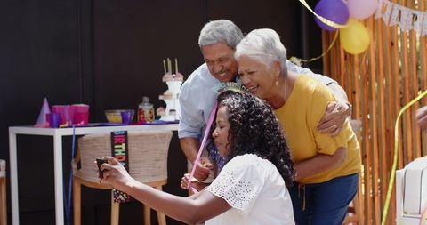 Cheerful Family Taking Selfie at Birthday Celebration with Decorations