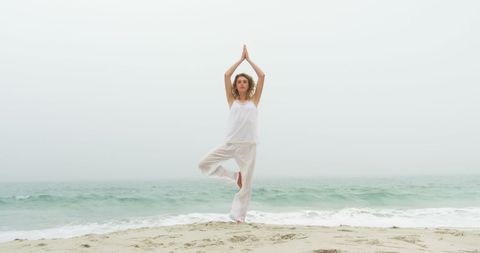 Serene Woman Practicing Yoga Pose on Tranquil Beach