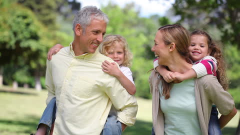Happy Family Enjoying Piggyback Ride in Park