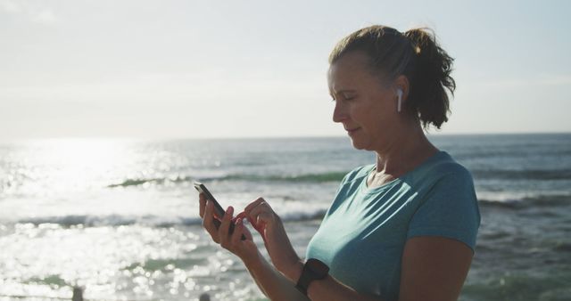 Middle-aged Woman Using Smartphone by the Ocean - Download Free Stock Images Pikwizard.com