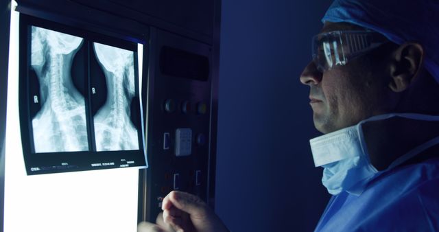 Doctor analyzing x-ray scans in dimly-lit medical room - Download Free Stock Images Pikwizard.com