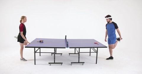 Athletic Duo Preparing for Ping Pong Game in Modern Studio