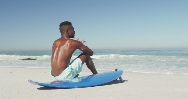 Young Man Sitting on Surfboard Looking at Ocean - Download Free Stock Images Pikwizard.com