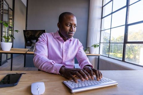 Professional man typing on keyboard in modern office space