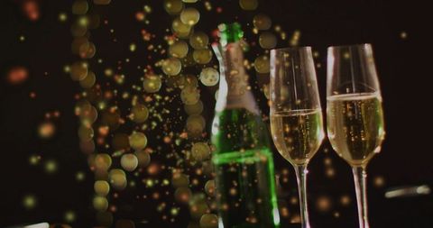 Toasting champagne flutes with green bottle amid golden bokeh lights for celebration