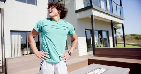 Young man taking breath during outdoor exercise at home