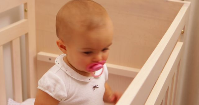 Cute Baby with Pacifier Sitting in Wooden Crib - Download Free Stock Images Pikwizard.com