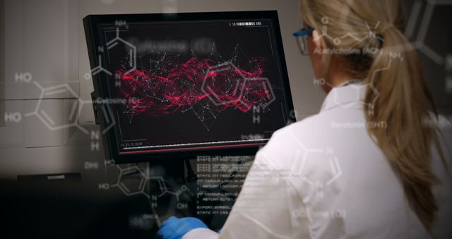 Scientist analyzing complex chemical data on computer screen in laboratory setting. Molecular structures and chemical compounds visible on the screen. Ideal for use in science articles, research publications, technology websites, and educational materials depicting modern scientific practices and research work.
