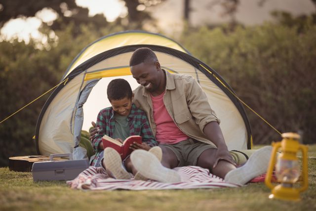 Father and Son Reading Book Outside Tent - Download Free Stock Photos Pikwizard.com