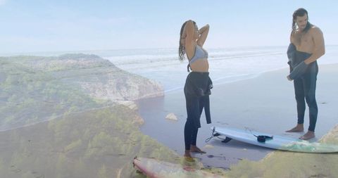 Surf Couple Preparing for Morning Session on Scenic Coastal Beach with Boards