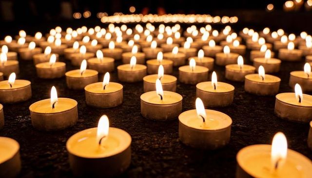 Endless Flickering Tealights Glowing at Chapel Shrine for Memorial and Quiet Contemplation
