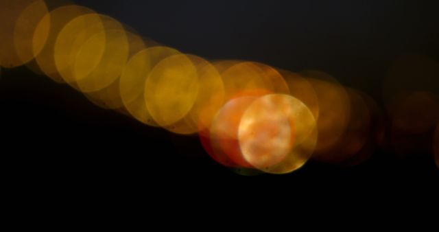 Bokeh lights create a warm, abstract background with a gradient from yellow to dark hues. This effect is often used to add a dreamy or festive atmosphere to visuals.
