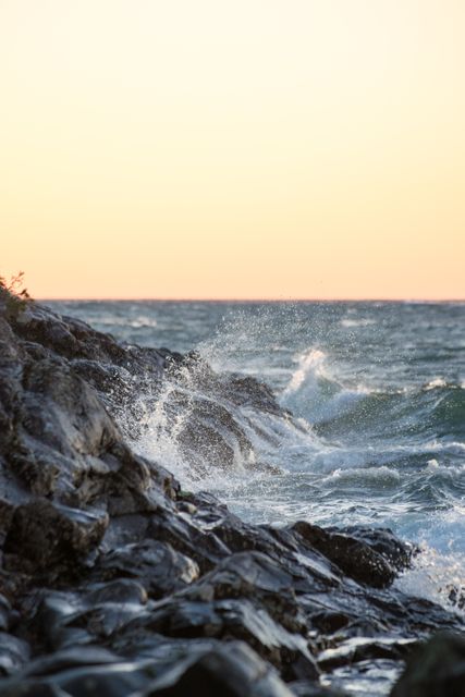 Serene Coastal Waves Crashing Against Rocky Shore During Sunset - Download Free Stock Photos Pikwizard.com