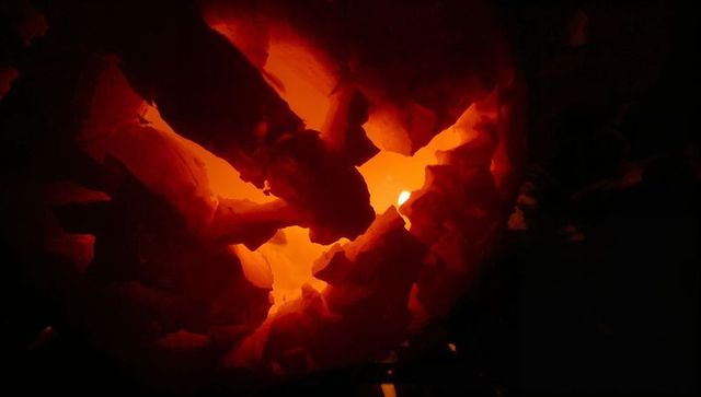 Glowing charcoal embers in furnace creating intense heat