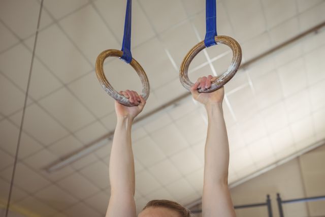 Close-up of a female gymnast practicing gymnastics on rings