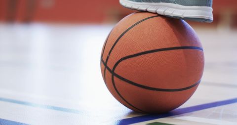 Basketball Focused on Court with Foot Resting on Top - Download Free Stock Images Pikwizard.com