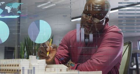 Architect Adding Precision Details to Scale Model with Digital Charts Overlay