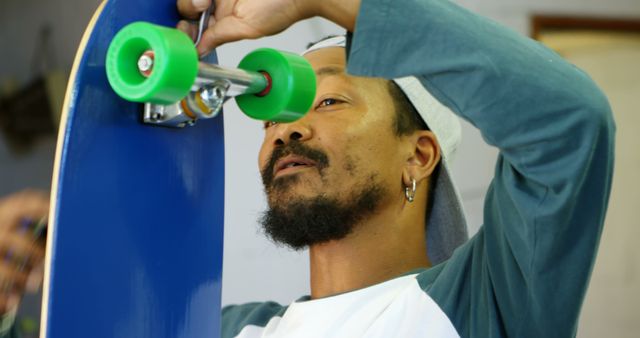 Man Assembling Skateboard with Green Wheels in Workshop - Download Free Stock Images Pikwizard.com