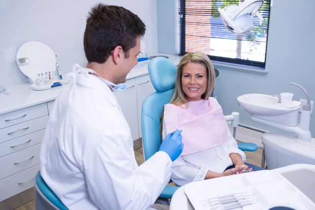 Smiling patient discussing with dentist at dental clinic