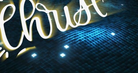 Neon cursive script casting warm halo over mosaic stage floor with blue led glow