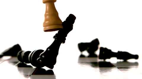White Chess Piece Topples Black Pieces on Board