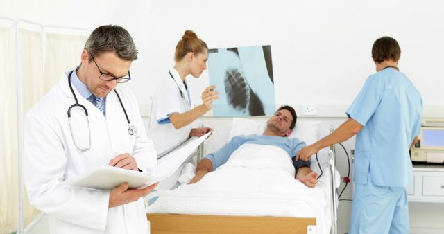 Team of Doctors Examining X-ray and Patient in Hospital Room - Download Free Stock Images Pikwizard.com