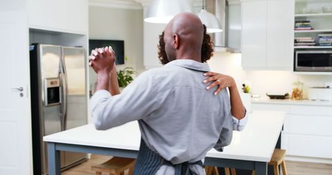 Middle-aged couple embracing in modern kitchen