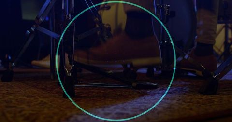 Close-up drummer foot pressing bass drum pedal on rug during rehearsal with moody lighting
