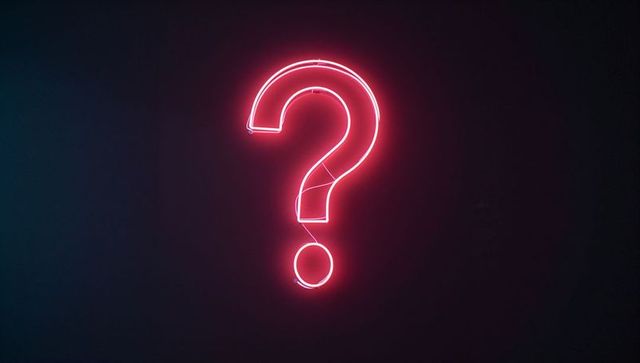 Glowing neon pink question mark on dark wall