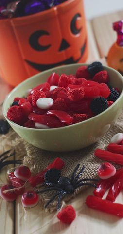 Colorful Halloween Candy with Pumpkin Container on Table - Download Free Stock Images Pikwizard.com