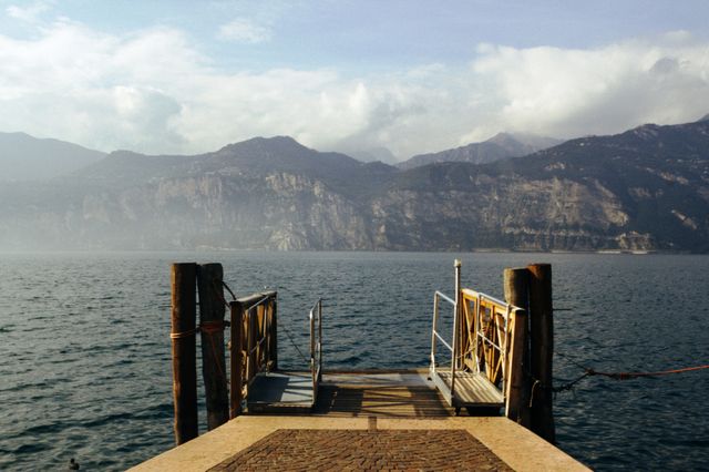 Serene Lakeside Dock with Mountains in Background on Foggy Day - Download Free Stock Photos Pikwizard.com