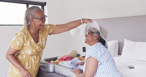 Joyful Elderly Friends Unpacking Luggage and Sharing Laughter