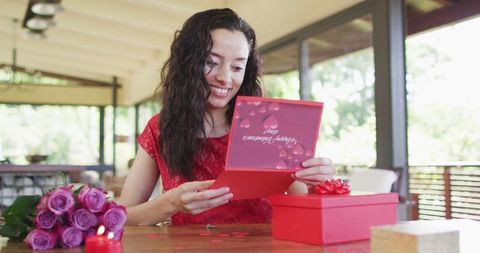 Woman Joyfully Opening Valentine's Card and Gifts at Home