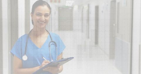 Smiling Nurse in Blue Scrubs Holding Clipboard in Hospital Hall
