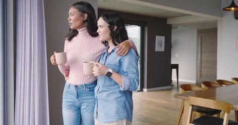 Diverse Female Friends Enjoying Leisure Time with Mugs