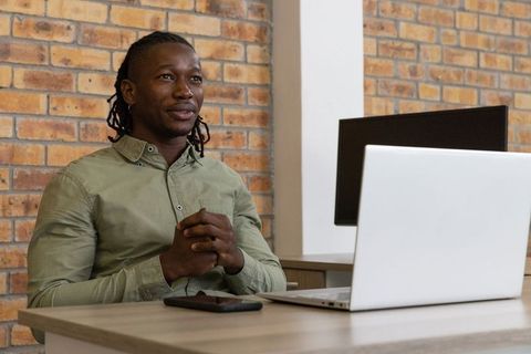 Confident Professional Working at Workspace with Laptop