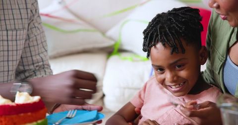 Family Celebrating Child's Birthday with Cake at Home