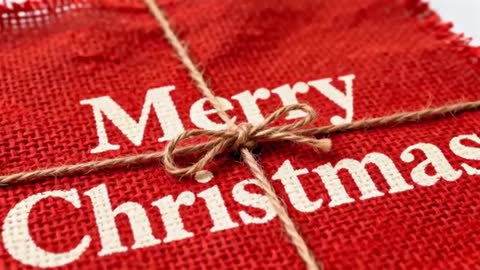 Macro video showing rustic red burlap Merry Christmas tag tied with twine bow and knot