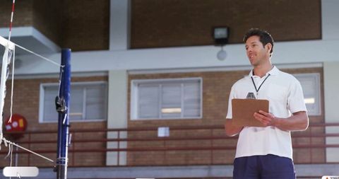 Volleyball coach analyzing game plan in gym