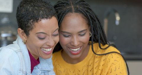 African american friends laughing together in cozy kitchen, sharing joy and conversation