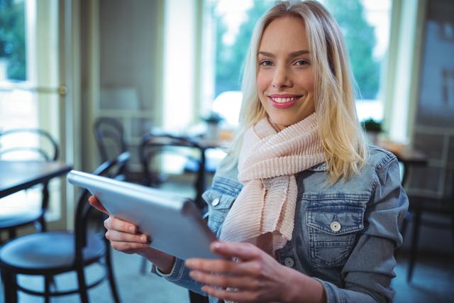 Portrait of smiling woman using digital tablet in cafe