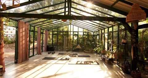 Serene Glass House Yoga Studio with Sunlight and Greenery