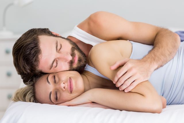 Young couple sleeping peacefully in bedroom, showcasing intimacy and comfort. Ideal for use in articles or advertisements related to relationships, sleep health, bedroom furniture, or lifestyle blogs focusing on love and togetherness.