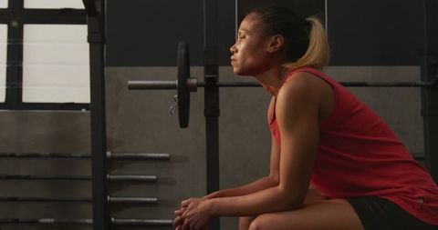 Determined woman resting on gym bench after intense workout