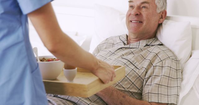 Senior Man Receiving Breakfast in Bed from Caregiver - Download Free Stock Images Pikwizard.com