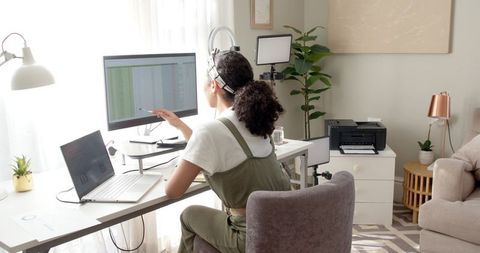 Focused Woman Analyzing Data on Computer in Home Office
