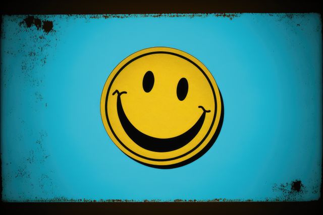 This image showcases a vintage-style smiley face with a distressed effect on a blue background. Perfect for use in retro-themed designs, social media posts promoting positivity, marketing materials, and posters. The nostalgic vibe can appeal to themes related to happiness and playful moods.